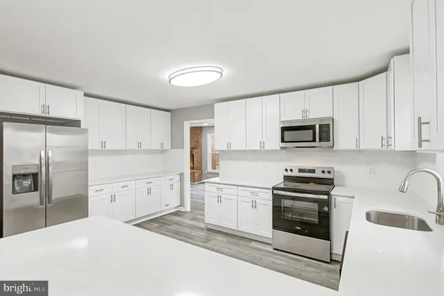 a kitchen with a white cabinets and wooden floor