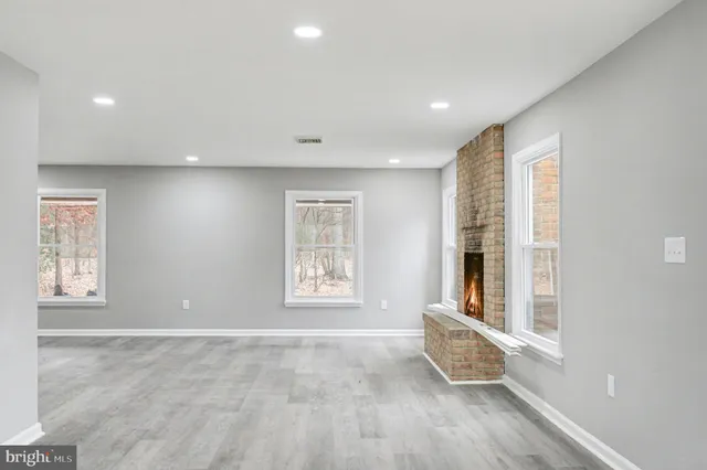a view of an empty room with a window and fireplace