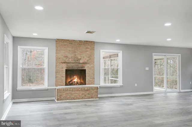 a view of an empty room with a window and fireplace