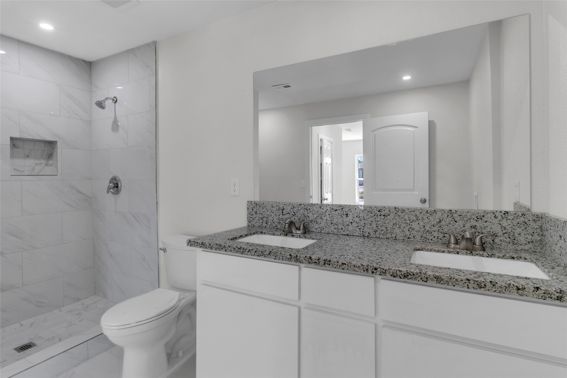 7622 Williams Street Houston, TX 77040 - Photo 19 of 42 a bathroom with a granite countertop sink a toilet and a mirror