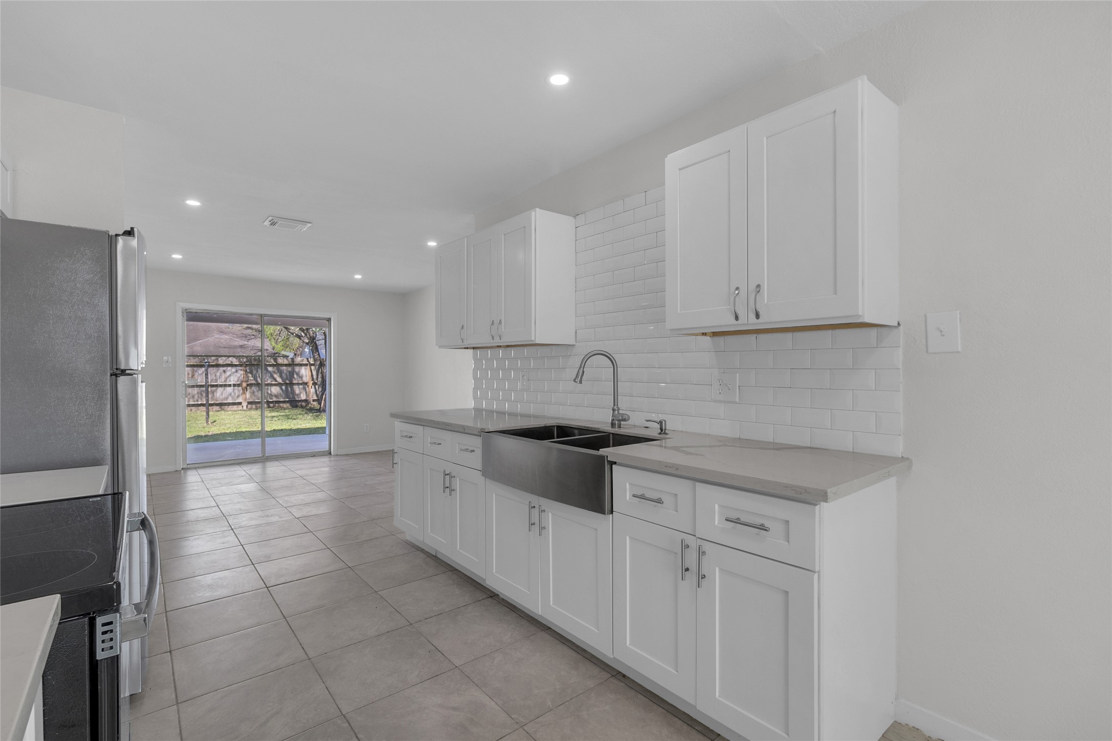 7622 Williams Street Houston, TX 77040 - Photo 10 of 42 a kitchen with granite countertop white cabinets and stainless steel appliances