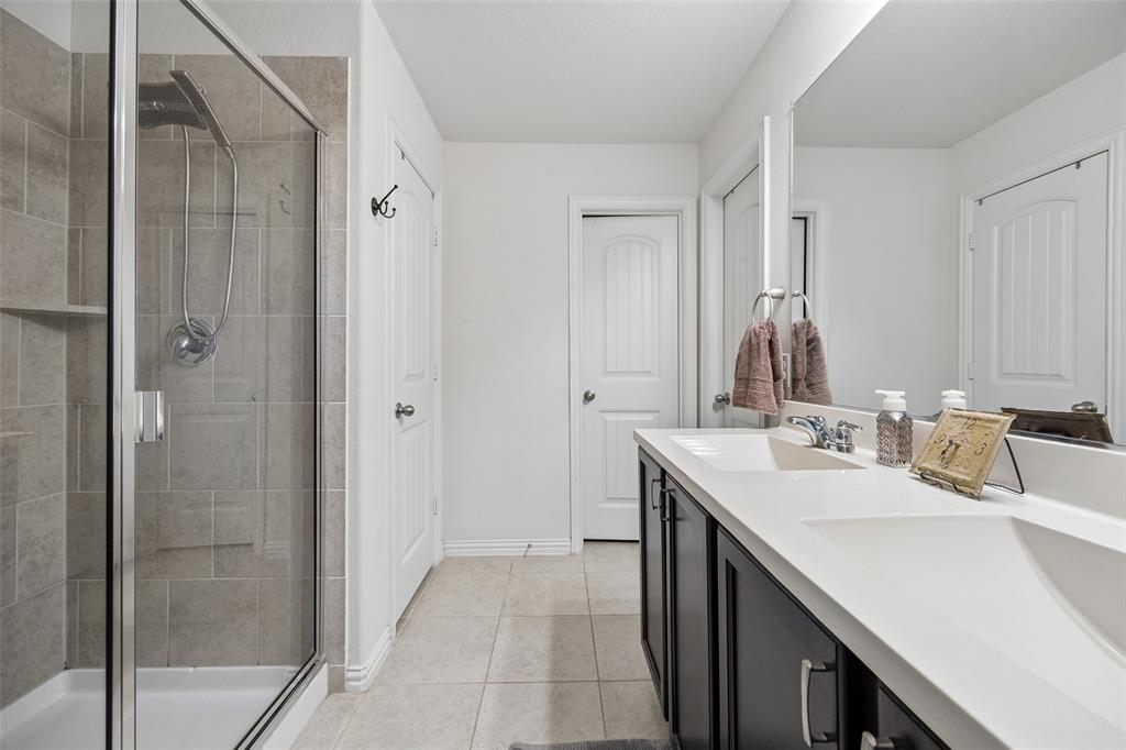 406 Madrone Lane Princeton, TX 75407 - Photo 14 of 30 Primary bathroom featuring a glass-enclosed shower with tile surround and integrated shelving