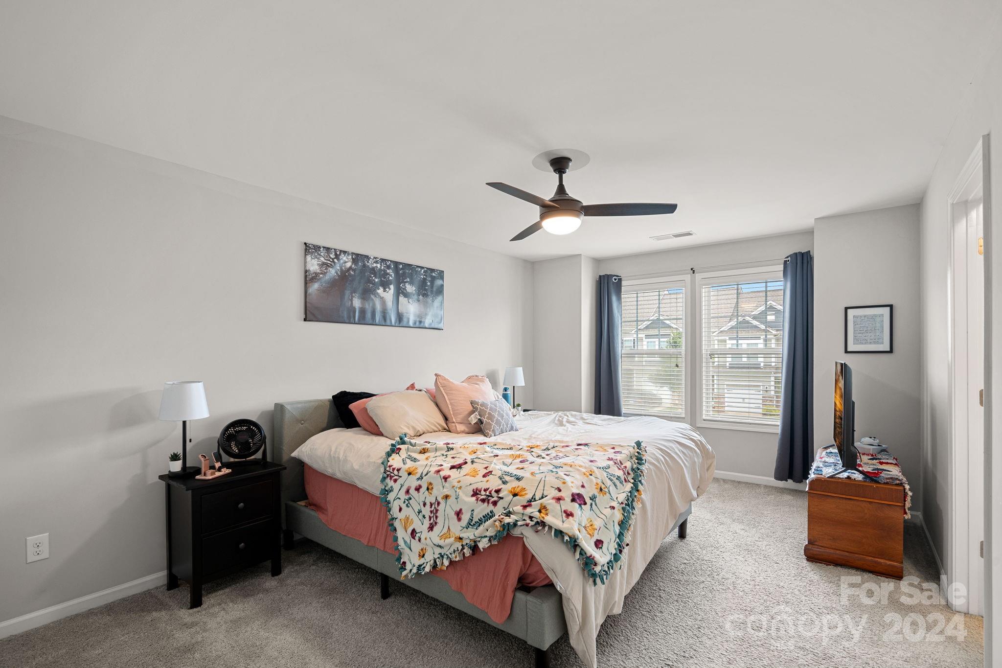 7044 Harris Bay Road Charlotte, NC 28269 - Photo 10 of 17 a bedroom with a bed and a chandelier