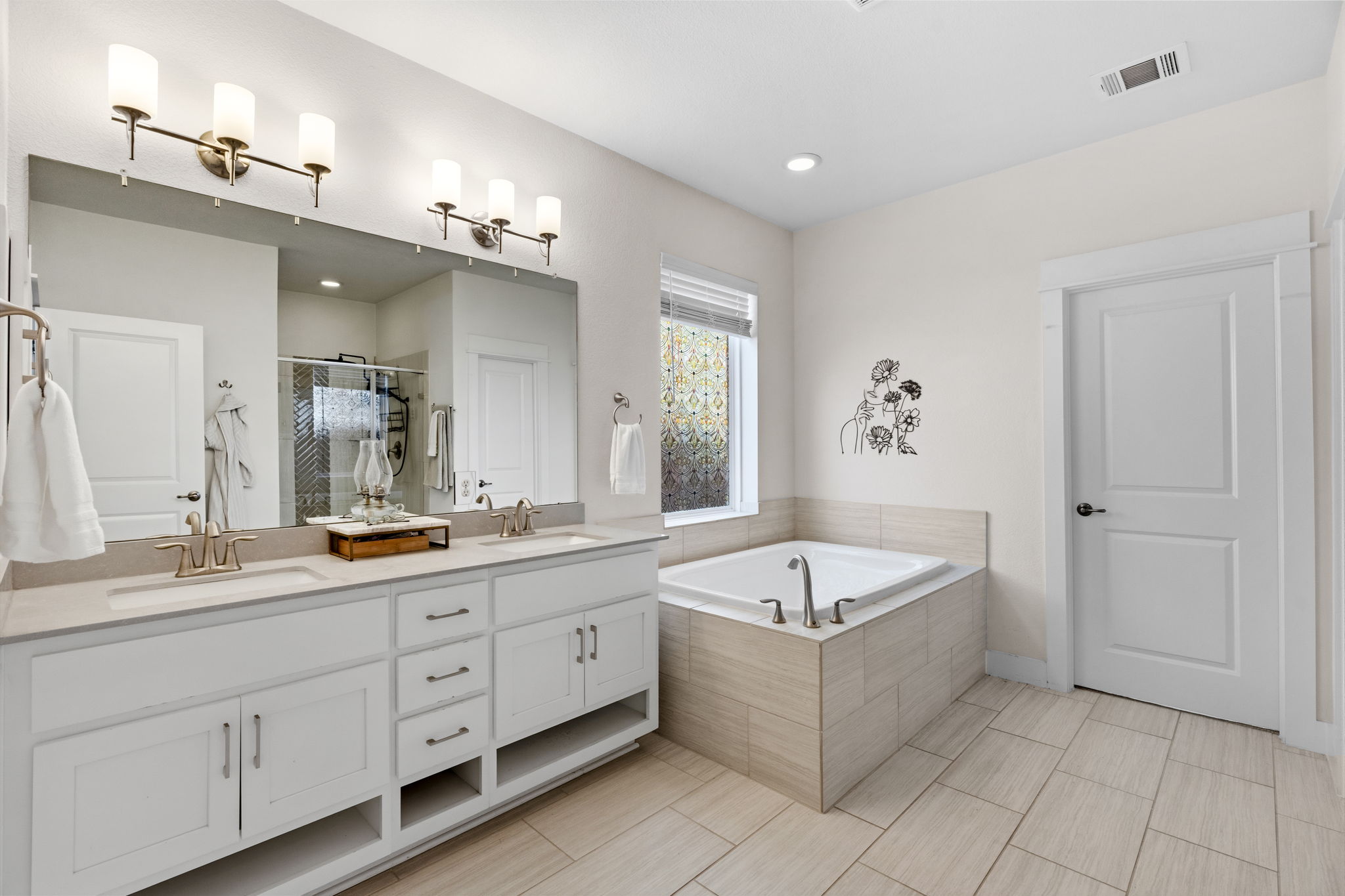 7205 Albert Road Austin, TX 78745 - Photo 19 of 24 The primary offers a spa-like ensuite bath with dual vanities and a dual shower head with rain shower and handheld shower.