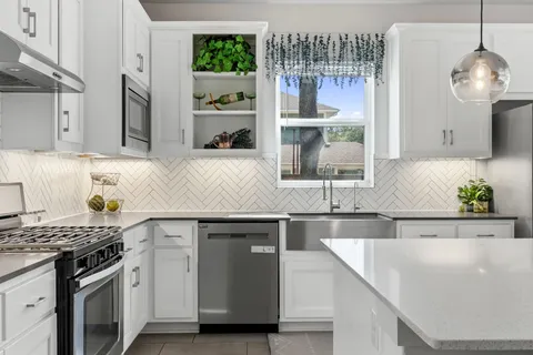 a kitchen with stainless steel appliances granite countertop a sink and a stove