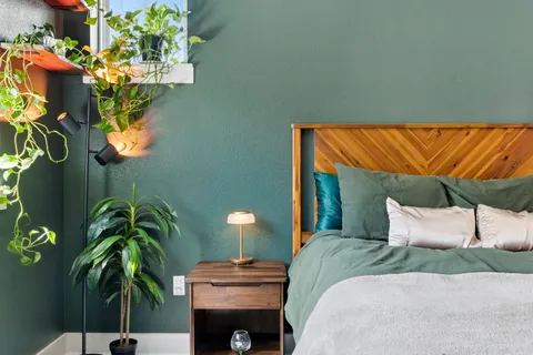 a bedroom with a bed and a potted plant