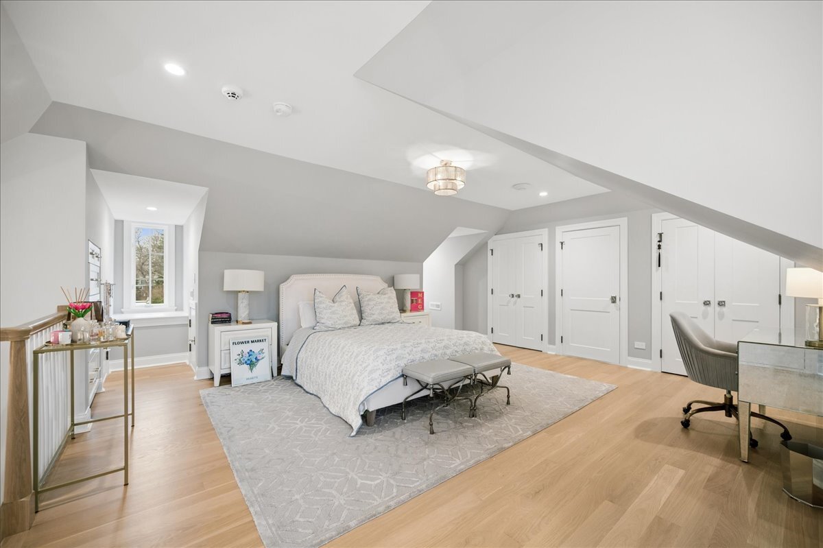 525 Ash Street Winnetka, IL 60093 - Photo 40 of 56 a spacious bedroom with a large bed a table and chair