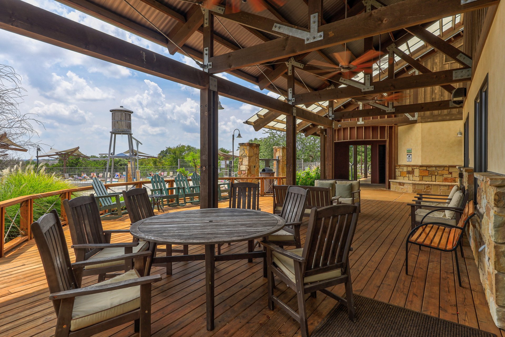 173 Santa Maria Street Georgetown, TX 78628 - Photo 35 of 39 Expansive outdoor deck featuring wood-finish flooring, a wood-beamed ceiling with corrugated metal roofing, and multiple ceiling fans