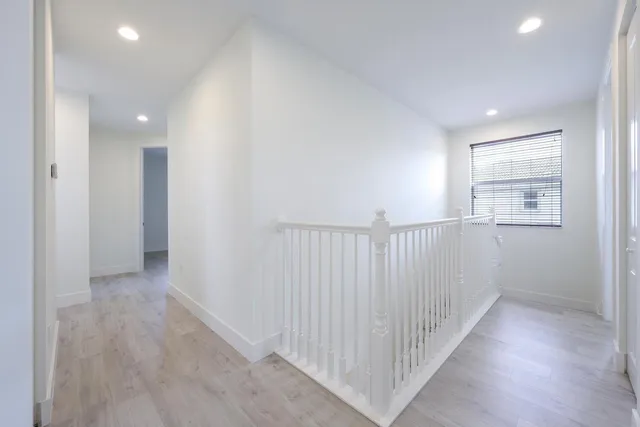 a view of an empty room and chandelier fan