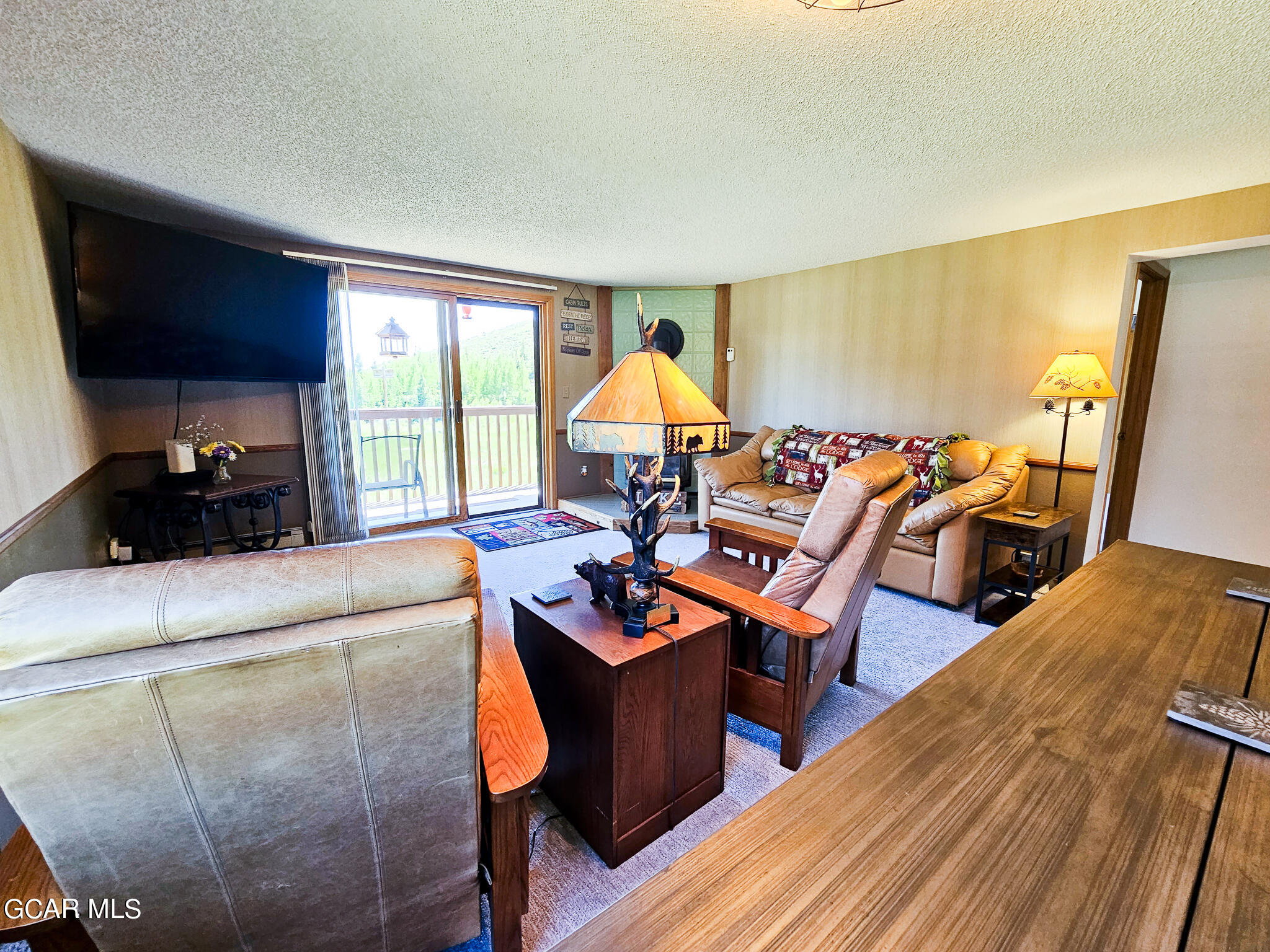 a living room with furniture a flat screen tv and a window