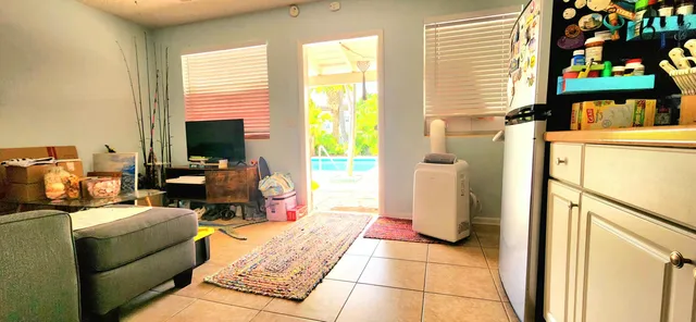 a living room with furniture a flat screen tv and a window