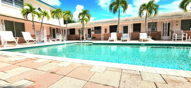a view of a house with a swimming pool and a chairs