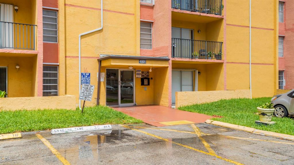 4801 Northwest 7th Street, Unit 50316 Miami, FL 33126 - Photo 23 of 31 a view of brick building with a yard and large tree