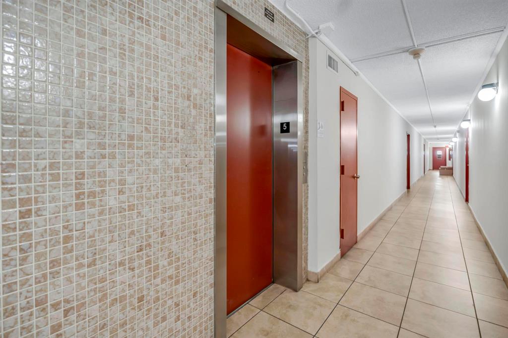 4801 Northwest 7th Street, Unit 50316 Miami, FL 33126 - Photo 27 of 31 a hallway with sliding door and chandelier