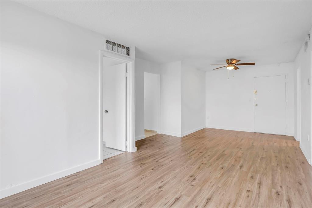 4801 Northwest 7th Street, Unit 50316 Miami, FL 33126 - Photo 4 of 31 a view of a room with wooden floor and white walls