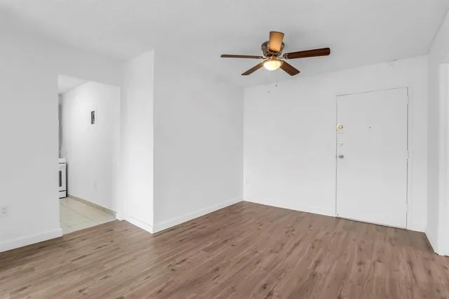 a view of empty room with wooden floor
