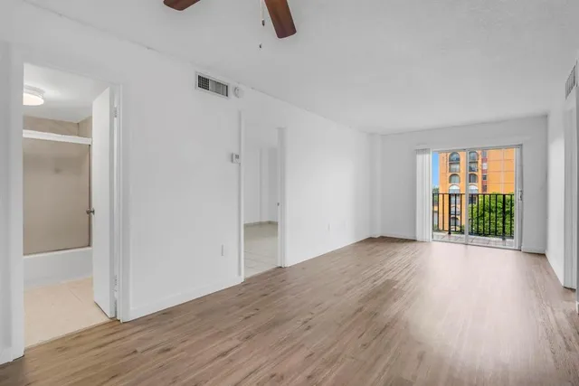 an empty room with wooden floor and windows