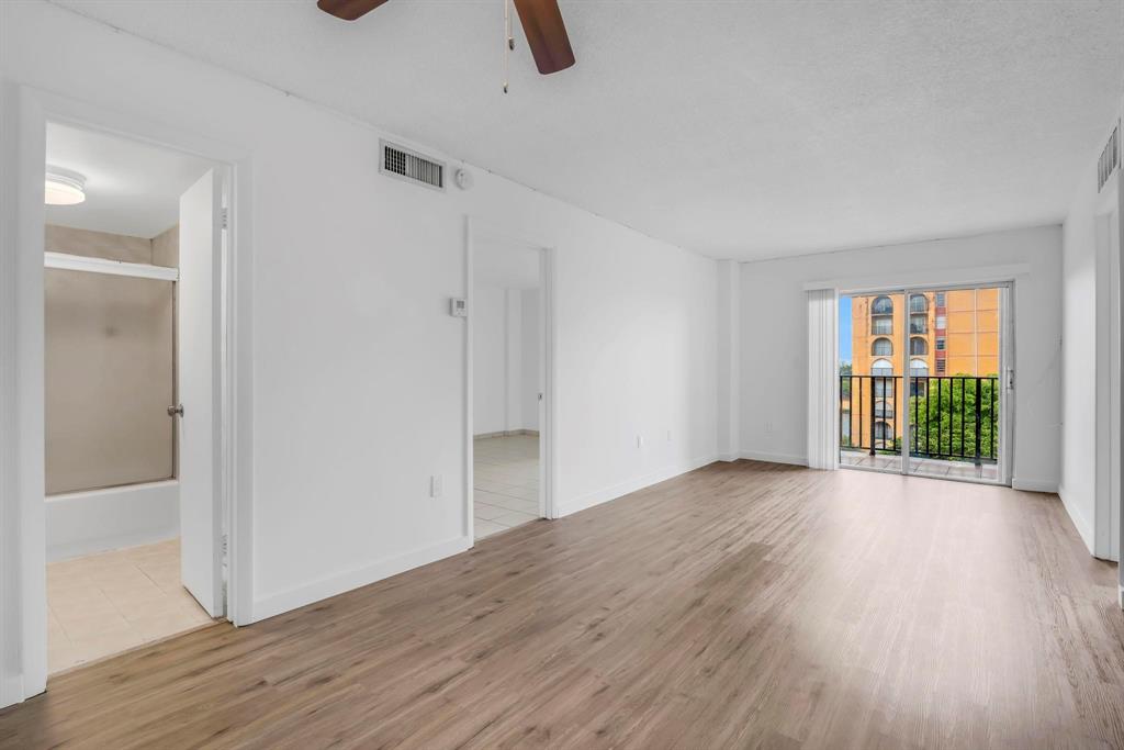 4801 Northwest 7th Street, Unit 50316 Miami, FL 33126 - Photo 8 of 31 an empty room with wooden floor and windows