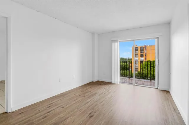 an empty room with wooden floor and a window