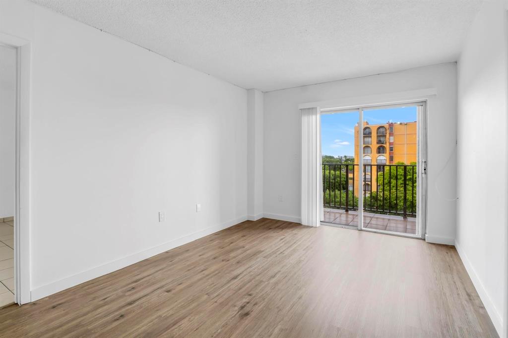 4801 Northwest 7th Street, Unit 50316 Miami, FL 33126 - Photo 10 of 31 an empty room with wooden floor and a window