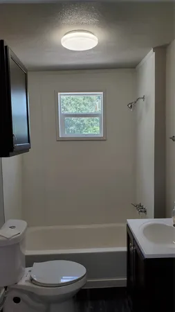 a bathroom with a toilet a sink and bathtub