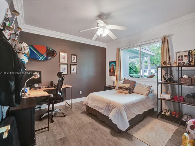 a bedroom with a bed a bookshelf a desk and chair with wooden floor