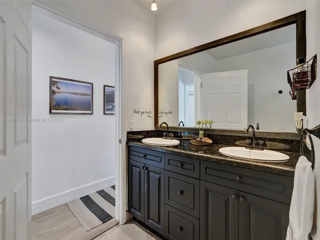 a bathroom with a double vanity sink and a mirror