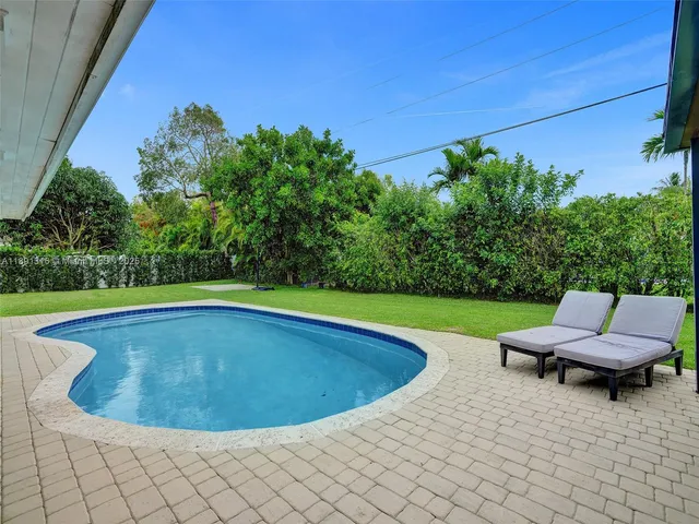 a view of a swimming pool and lounge chairs