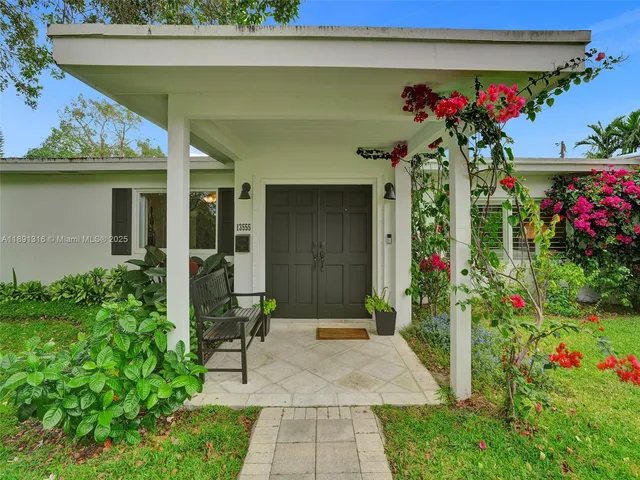 a front view of a house with a porch and a garden