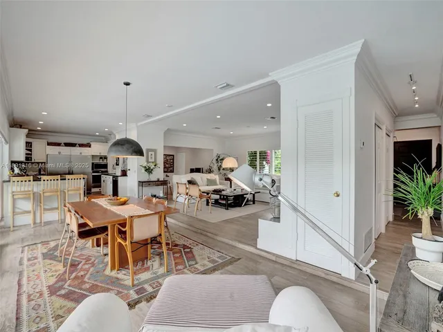 a living room with furniture a table and kitchen view