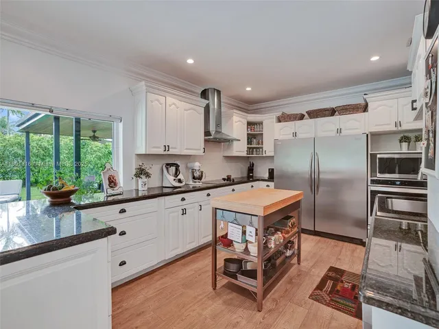a kitchen with a refrigerator a sink and cabinets
