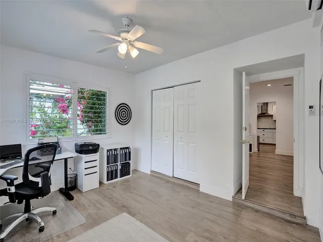 a view of a workspace with furniture and a window