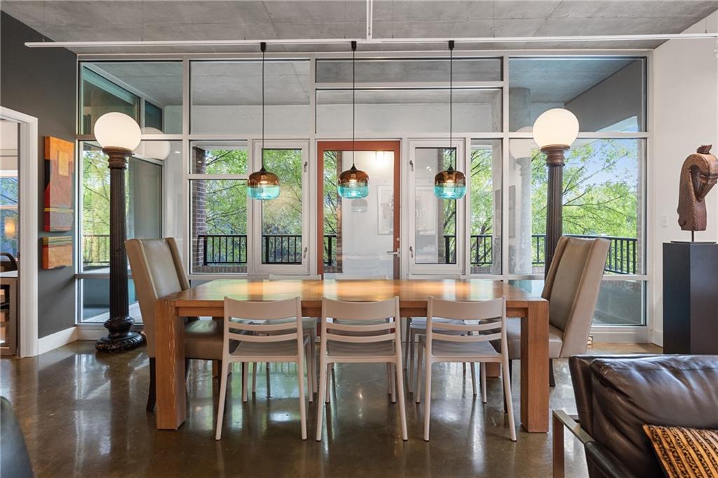 845 Spring Street Northwest, Unit 129 Atlanta, GA 30308 - Photo 13 of 48 a view of a dining room with furniture large windows and wooden floor