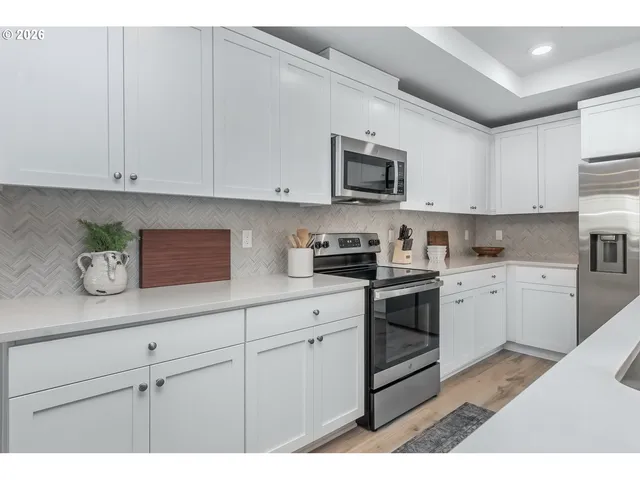 a kitchen with stainless steel appliances granite countertop white cabinets a sink and dishwasher