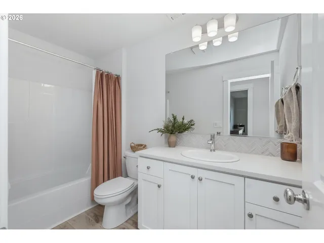 a bathroom with a sink vanity granite toilet and a mirror