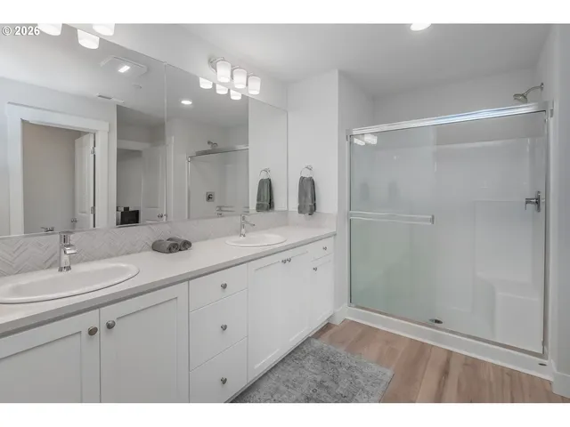 a bathroom with a double vanity sink mirror and shower