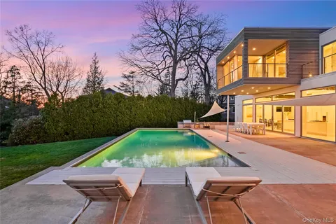 a small pool with lawn chairs and a yard