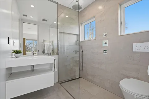a bathroom with a sink a toilet and shower