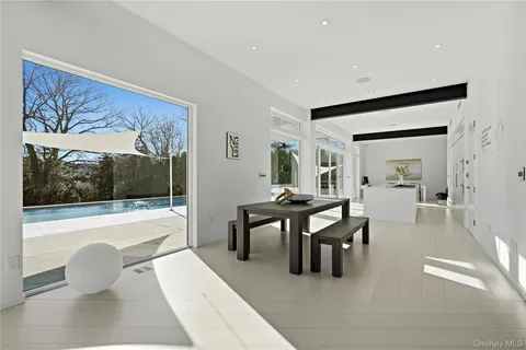 a dining room with furniture and a large window