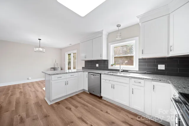 a kitchen with granite countertop white cabinets and white appliances