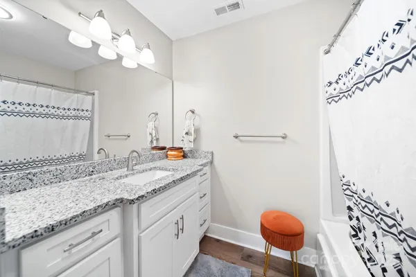 a bathroom with a granite countertop sink a toilet and a mirror