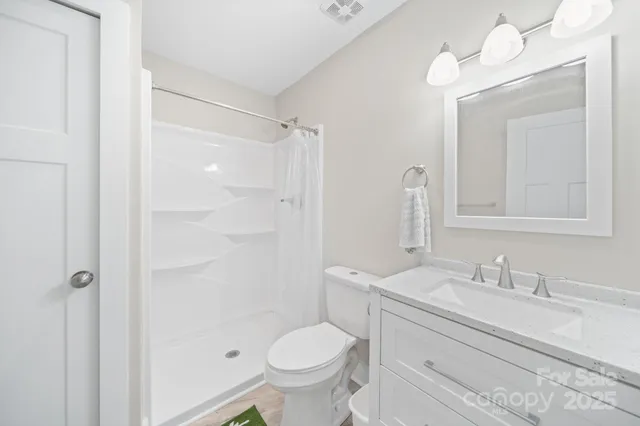 a bathroom with a granite countertop toilet sink and a mirror