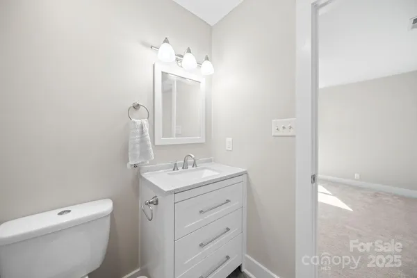 a bathroom with a toilet a sink a vanity and mirror