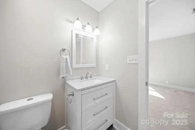 a bathroom with a toilet a sink a vanity and mirror