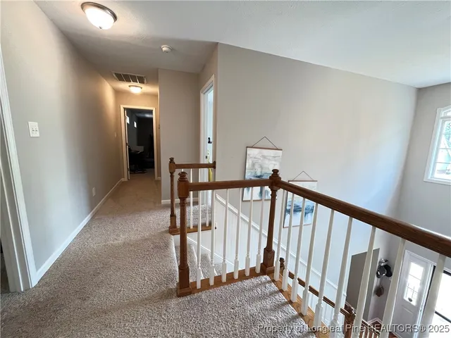 a view of a hallway with bathroom and a bathroom