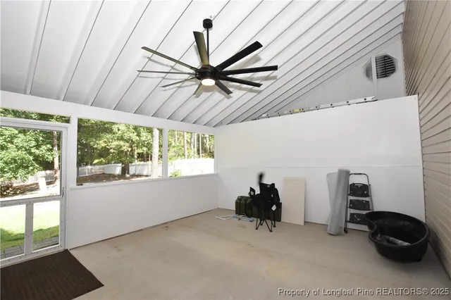 a view of a house with a big yard potted plants and large tree