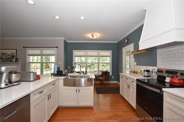 a kitchen with a sink stove and white cabinets