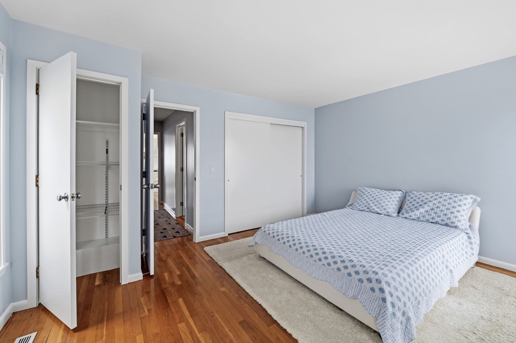 60 Brackett Place, Unit D Marblehead, MA 01945 - Photo 27 of 30 a bedroom with a bed and wooden floor