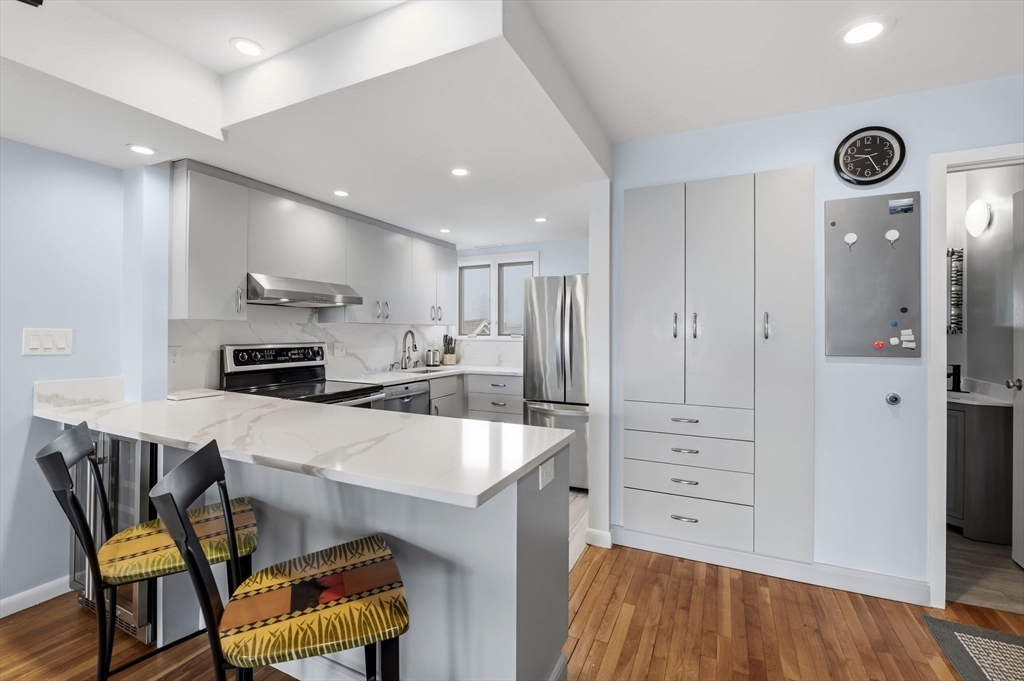 60 Brackett Place, Unit D Marblehead, MA 01945 - Photo 7 of 30 a kitchen with a table chairs refrigerator and microwave