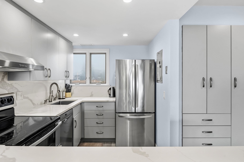 60 Brackett Place, Unit D Marblehead, MA 01945 - Photo 8 of 30 a kitchen with a refrigerator and cabinets